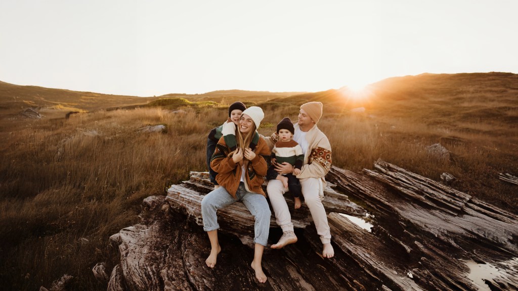 Family portrait at golden hour on hilltop rocks — Sydney photography